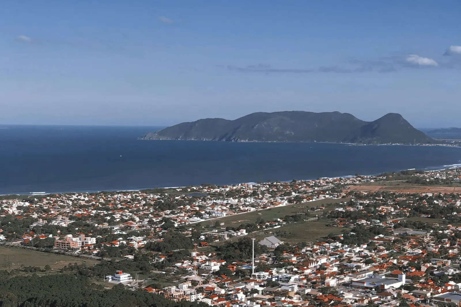 Vista alta do bairro do Campeche e da Ilha do Campeche ao fundo, com o mar azul e o céu limpo